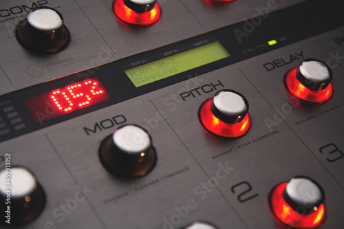 Foot controller in recording studio, work on music in progress: filter off, loops on (mod, pitch, delay, reverb), red and green displays, red buttons shine