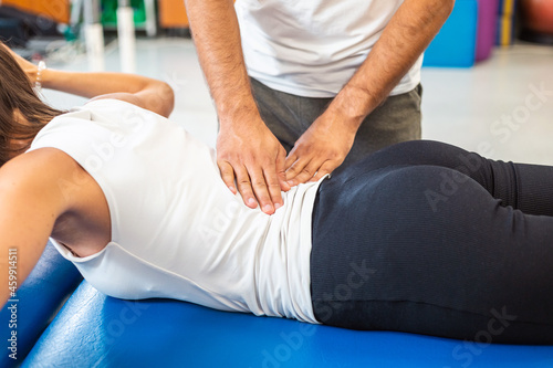 Canvas Print Physiotherapist hands pressing female patient low back