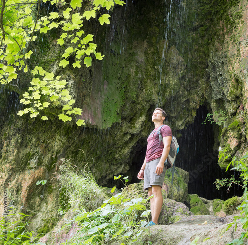 Adult man enjoys nature while hiking at Sipote waterfall, Transy photo