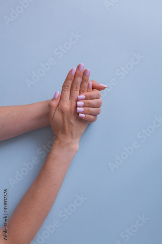 Trendy pink manicure. View from above of beautiful women's hands. Delicate skin.