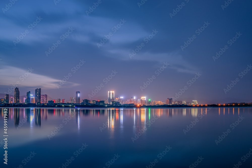 At dusk, the lake reflects the night view of the city