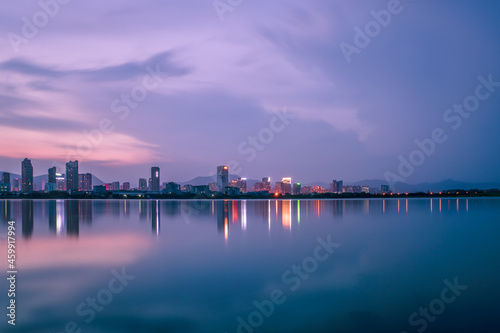 At dusk  the lake reflects the night view of the city
