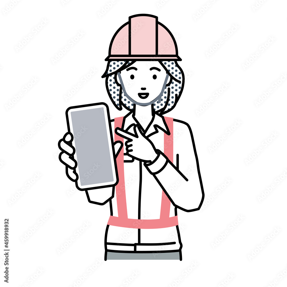 立ってスマートフォンを指差してこちらに向けて見せている工事現場の女性 立ってスマートフォンを指差してこちらに向けて見せている工事現場の女性