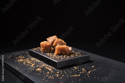 Gourmet quince jelly paste in ceramic plate on black background photo