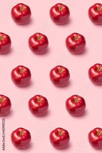 Red apples on pink background. Pattern, top view, flat lay.