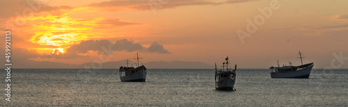 Boats at sea, backlit, at sunset time