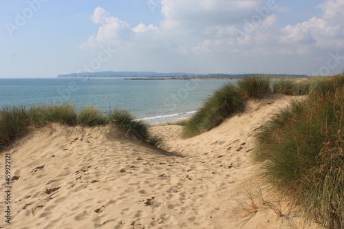 Camber sands East Sussex UK - view of Camber Sand dunes with sky and sea dunes held together with grasses stopping sand blowing away