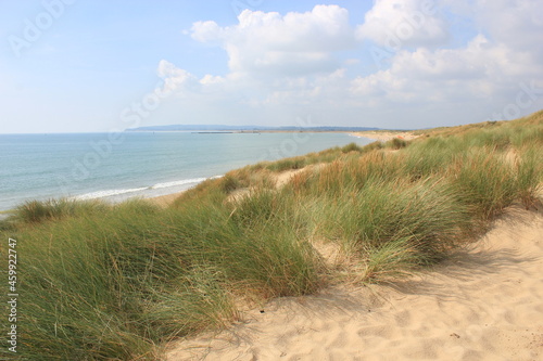 Camber sands East Sussex UK - view of Camber Sand dunes with sky and sea dunes held together with grasses stopping sand blowing away