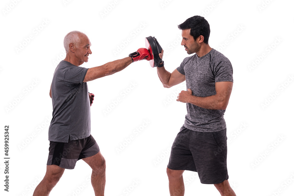 Elderly man hits with boxing glove in defense, personal fitness trainer, concept of working together. On white background.