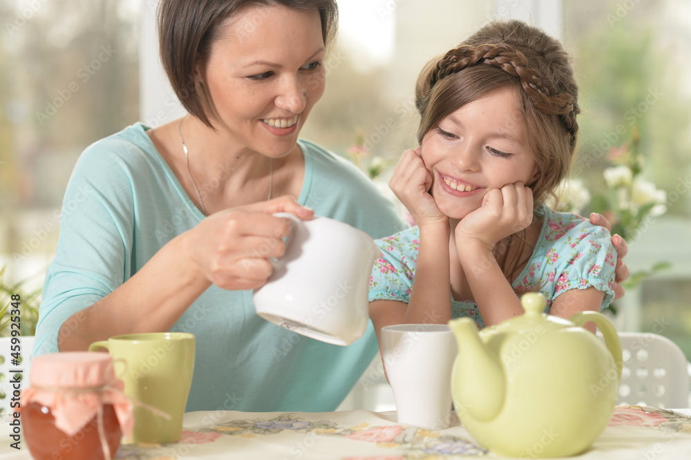 Young mother and her daughter drinking tea at home Young mother and her daughter drinking tea at home