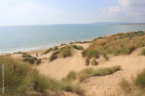 Camber sands East Sussex UK - view of Camber Sand dunes with sky and sea dunes held together with grasses stopping sand blowing away