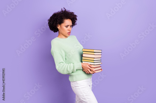 Photo of young unhappy upset dark skin sad woman hold hands books bad mood heavy isolated on purple color background