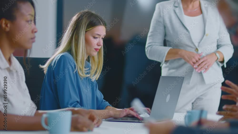 People at department meeting. Young blonde woman typing on laptop computer. Modern open space office interior. People at department meeting. Young blonde woman typing on laptop computer. Modern open space office interior.
