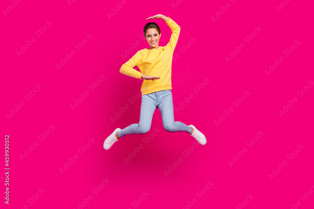 Full length body size view of attractive cheerful girl jumping showing size isolated over bright pink color background