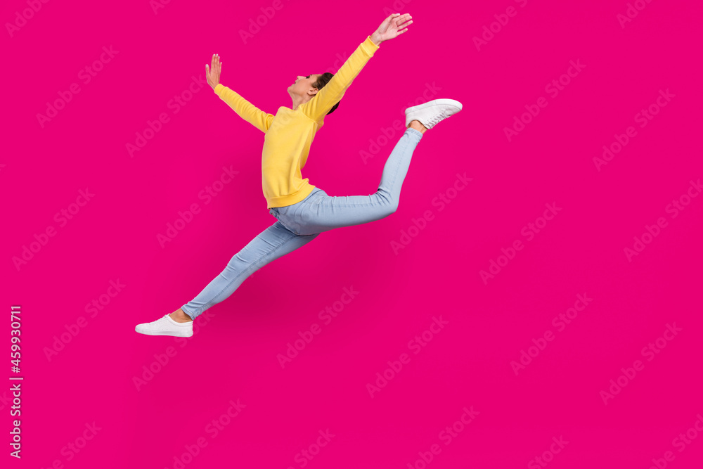 Photo of slim funny young lady wear yellow jumper smiling jumping high stretching isolated pink color background Photo of slim funny young lady wear yellow jumper smiling jumping high stretching isolated pink color background