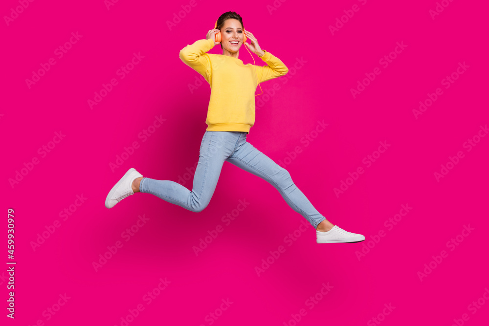 Full length body size view of attractive cheerful girl jumping running listening song isolated over bright pink color background