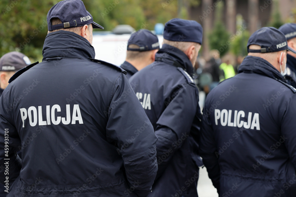 Polscy policjanci w niebieskim mundurze na zabezpieczeniu imprezy w mieście. - obrazy, fototapety, plakaty 