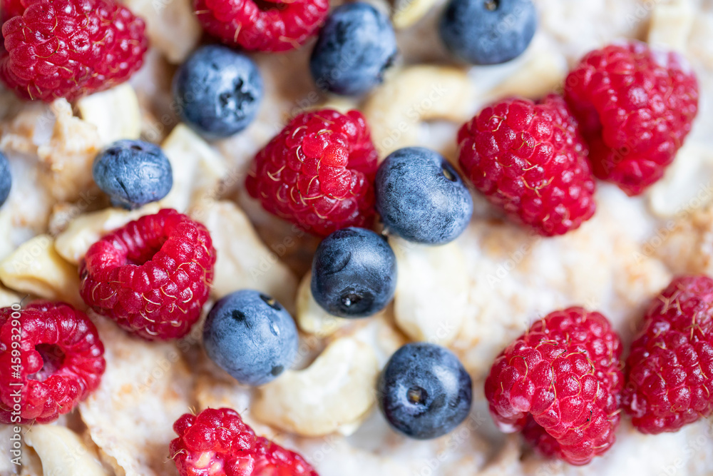 Whole grain oat flakes with fresh ripe blueberries, raspberries, yogurt and vegan almond milk close up. Healthy breakfast concept Whole grain oat flakes with fresh ripe blueberries, raspberries, yogurt and vegan almond milk close up. Healthy breakfast concept