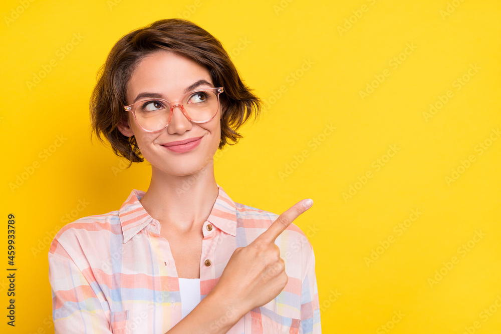 Photo of dreamy pretty young woman point finger sale empty space wear spectacles isolated on yellow color background Photo of dreamy pretty young woman point finger sale empty space wear spectacles isolated on yellow color background