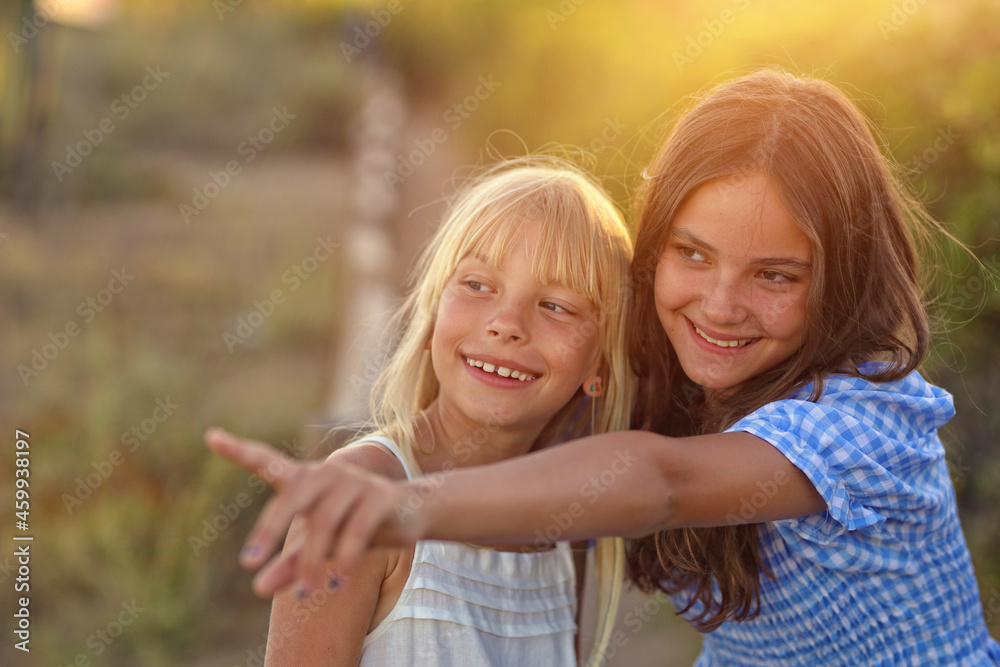 two cute young girls are laughing outside two cute young girls are laughing outside