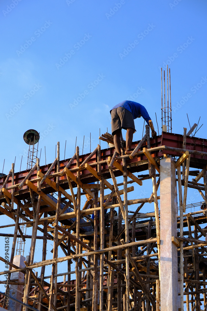 Safety concept: Construction workers are working at heights on the construction site. No protective equipment, not safe