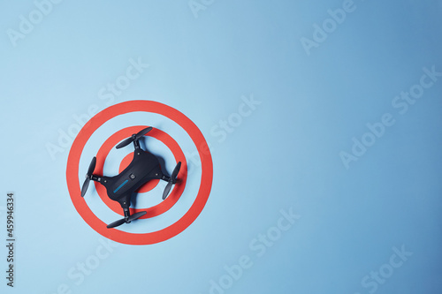 Aerial top down view on isolated drone copter landed in the center of reached red target on the bright solid blue fond background