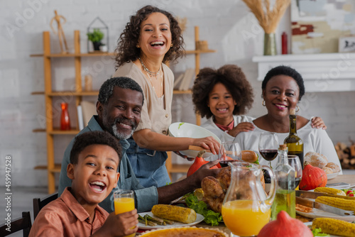 Smiling african american family looking at camera near thanksgiving dinner