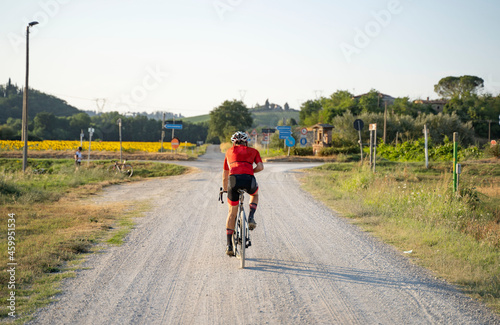 ragazzo in bicicletta su strada sterrata bianca in toscana