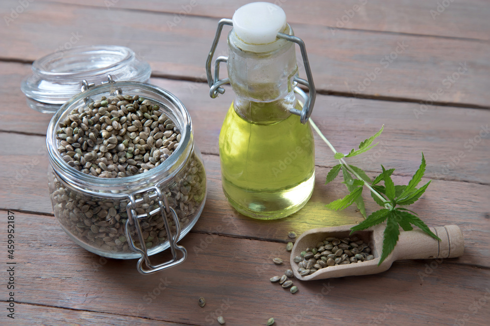 Close-up of hemp seed oil, rich in vitamins and minerals on a wooden table. Alternative oil Close-up of hemp seed oil, rich in vitamins and minerals on a wooden table. Alternative oil