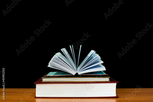 The book placed on the wooden table was opened.