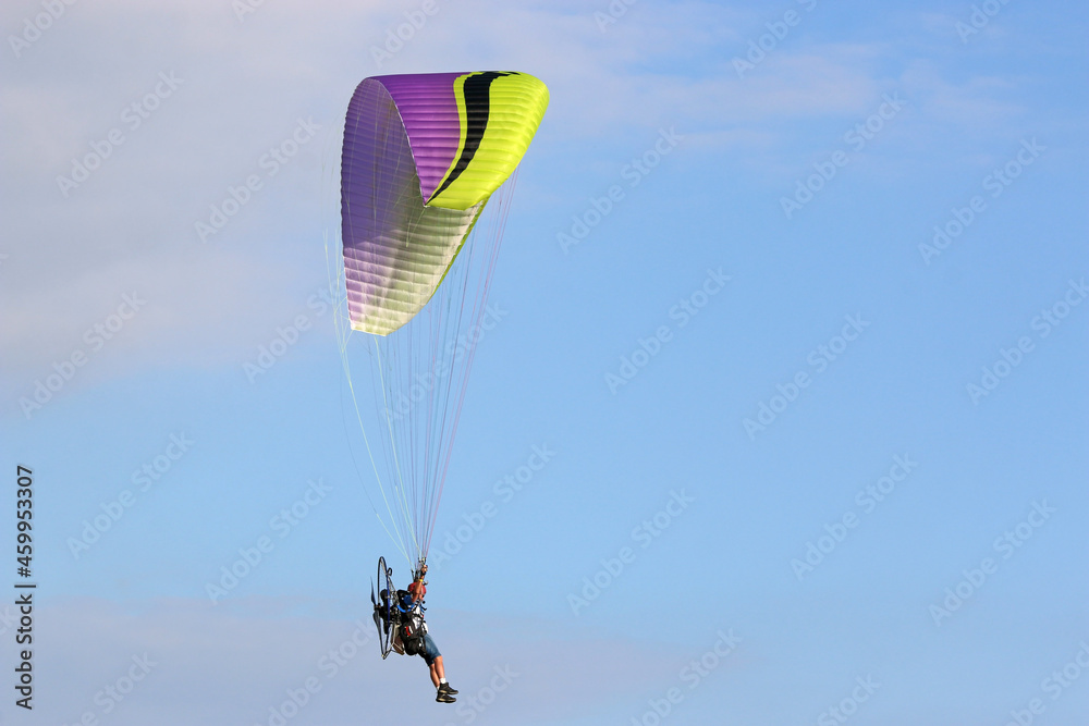 Paramotor pilot flying in a blue sky Paramotor pilot flying in a blue sky
