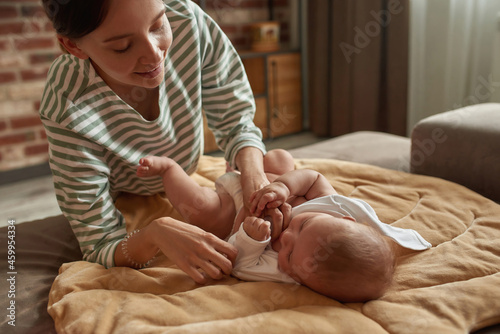 Tender mother and sweet baby during motning dressing routine photo