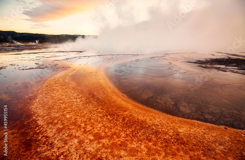 Sunset over steaming Grand Prismatic Spring in Yellowstone National Park, Wyoming, USA.