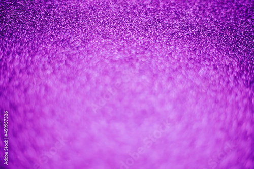 A blurry shimmering background of violet-colored sequins. Silver glitter, light abstract bokeh texture.