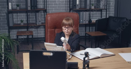 Funny little businesswoman talking by phone in office