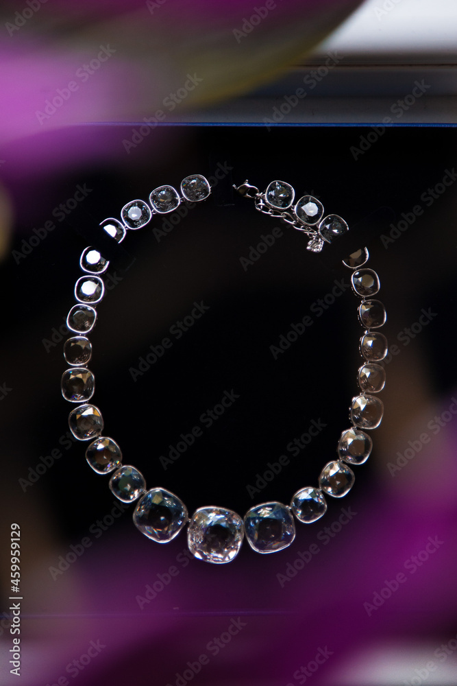 An elegant jewelry. White gold and diamonds necklace on black background. An elegant jewelry. White gold and diamonds necklace on black background.