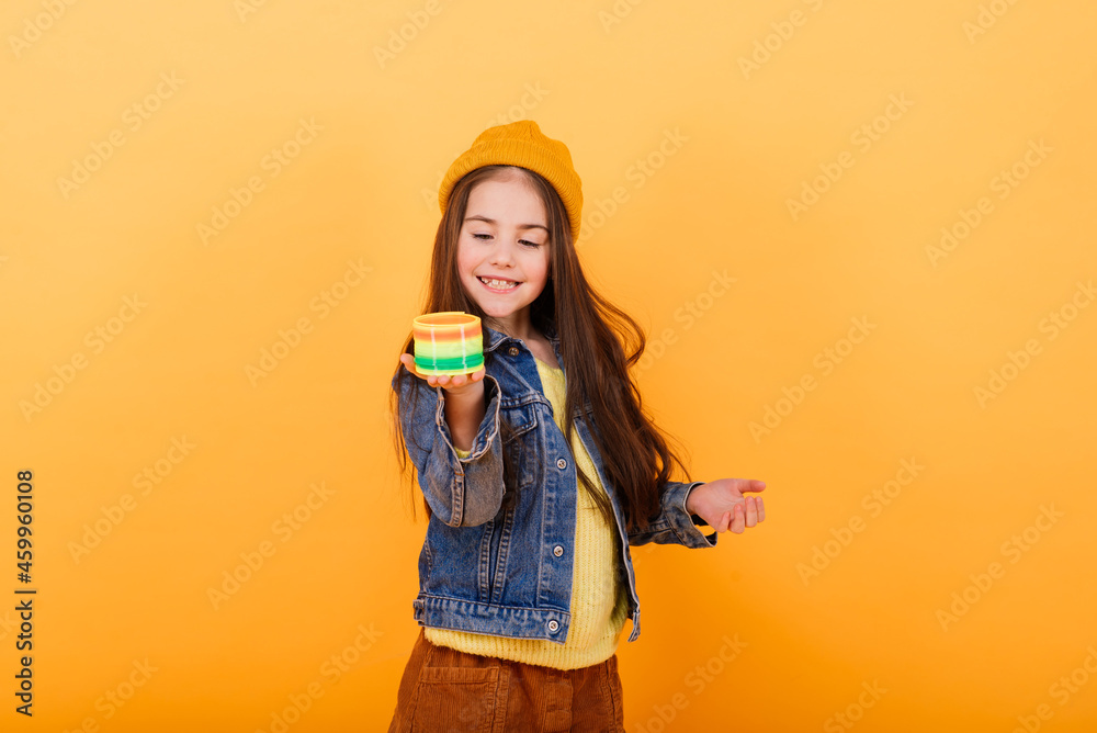 Cute little girl wearing bright stylish clothes on yellow colorful background Cute little girl wearing bright stylish clothes on yellow colorful background