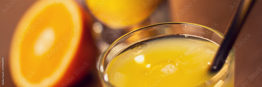 glass with fresh orange juice on wooden table close up
