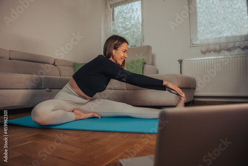 Woman stretching while training and doing her fitness routine at home
