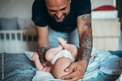 Fotografie Tattooed bearded father playing with his son