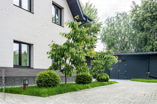 Home Landscaping.  House with plants and granite paving stones.