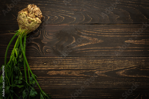 Root vegetable celera with green leaves on a wooden background, farm vegetables photo