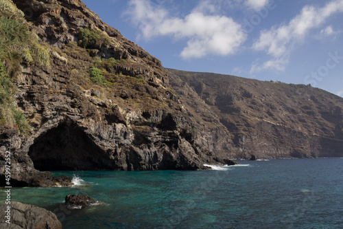 large, dark cavern that lies at the base of a cliff and receives the waters of the beautiful mediterranean sea.