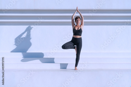 Woman doing yoga tree pose outdoors