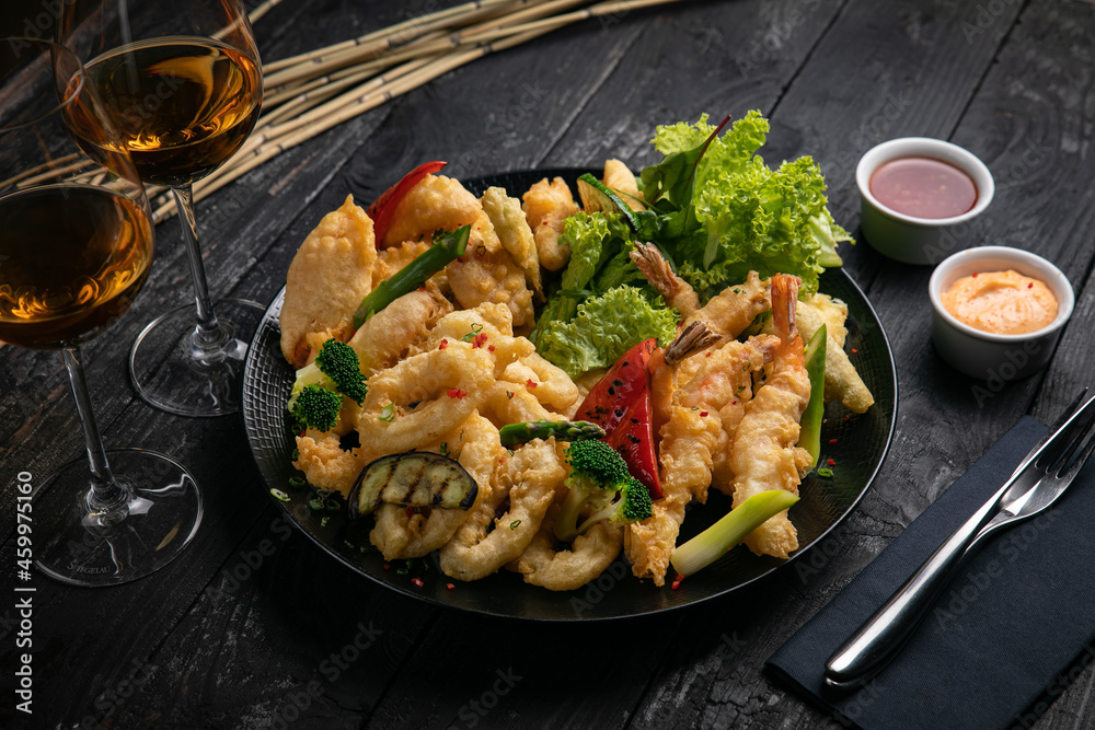 assorted grilled seafood with sauce and white wine on a black table.
assorted grilled seafood with sauce and white wine on a black table.