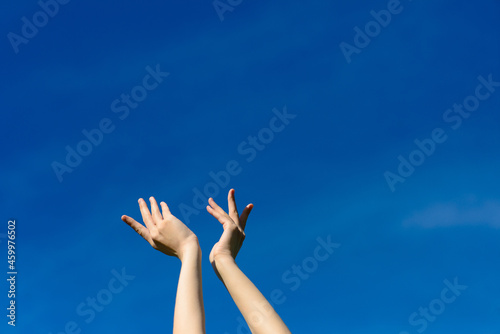 I wish we could touch the sky, female stretching hands to blue sky