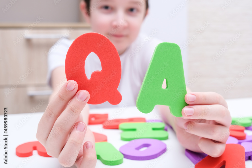 A boy holding colorful letters Q and A, questions and answers concept, solvation kids problems A boy holding colorful letters Q and A, questions and answers concept, solvation kids problems