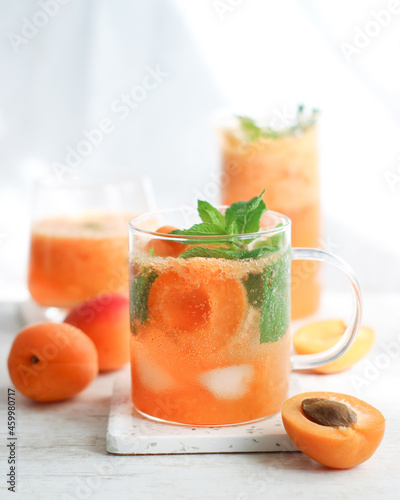 Glass of non-alcohol fresh apricot fruit mojito soda and mints with ice a cold drink for refreshing in summer  with isolated white bckground