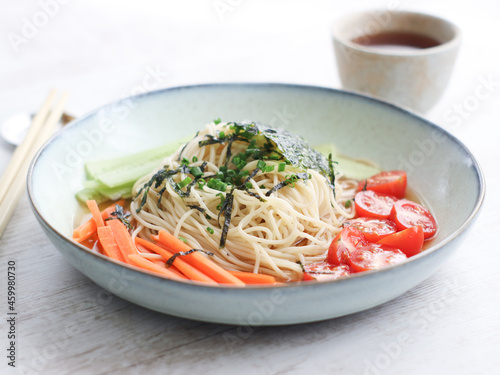 Japanese cold zaru noodles made with a spaghetti angel hair with cold soy mirin sauce served with mixed vegetables such as carrots, cucumber and cherry tomatoes. A chilling summer dish
