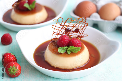 Photography Plate of cream caramel custard with spun sugar decoration, strawberries and raspberries